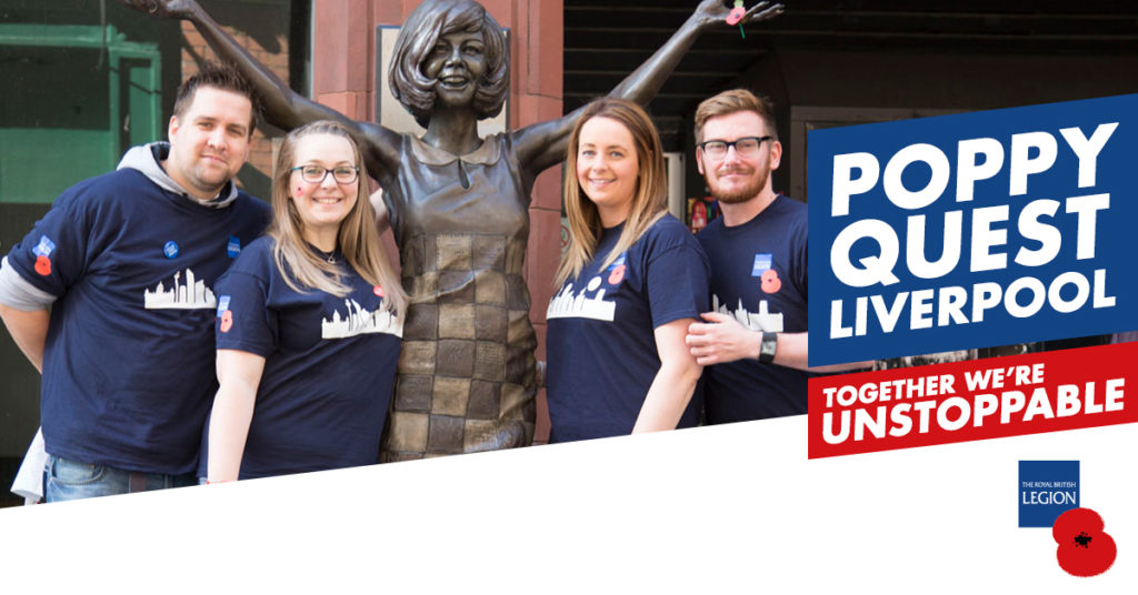 People standing in front of the Cilla Black statue with a British Legion logo
